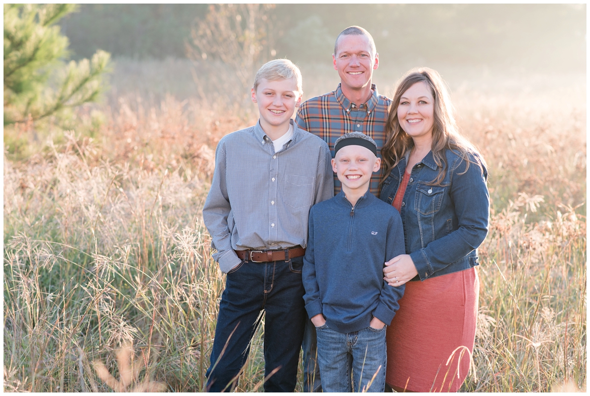 Kingwood photographer's sunrise session in tall, light-colored grass with family of four